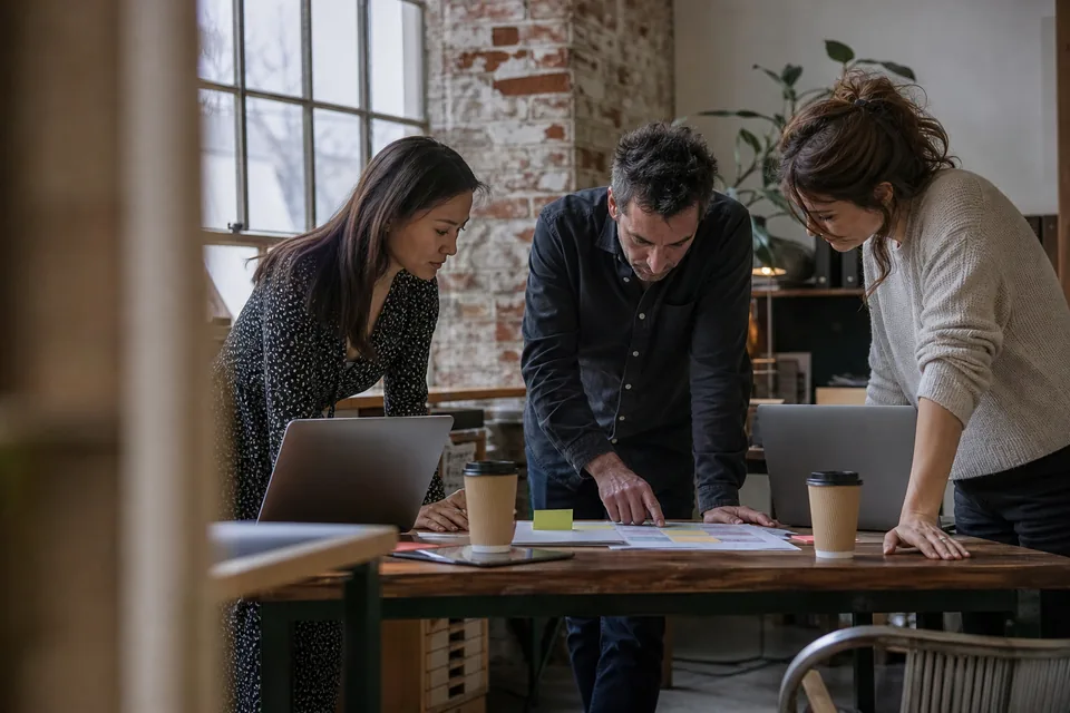 Small agency team reviewing creator verification records around one desk